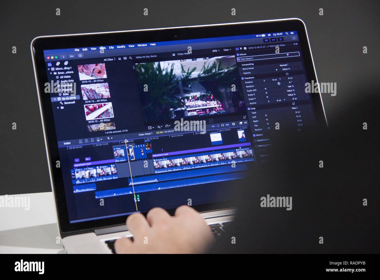 editor color grading corporate footage on laptop