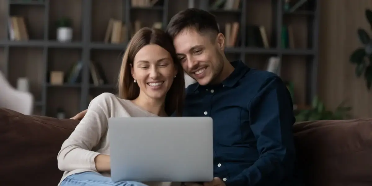 couple watching their wedding film on laptop