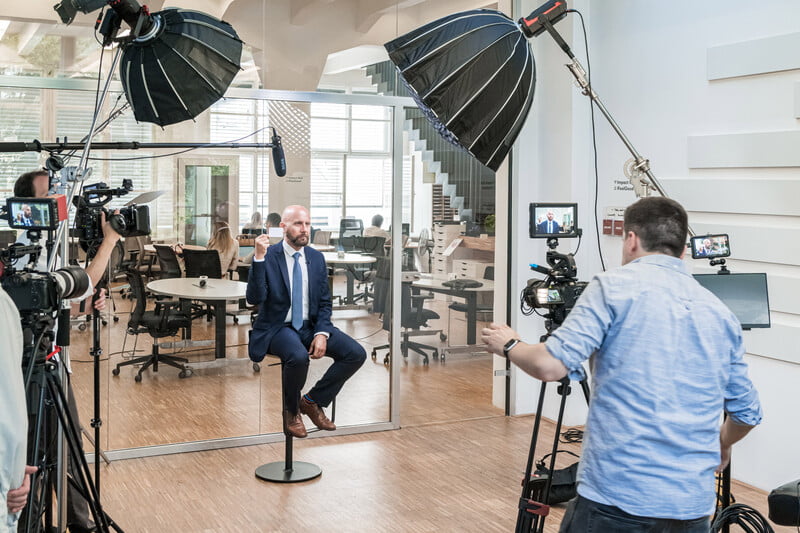 video crew filming an employee interview in a modern office
