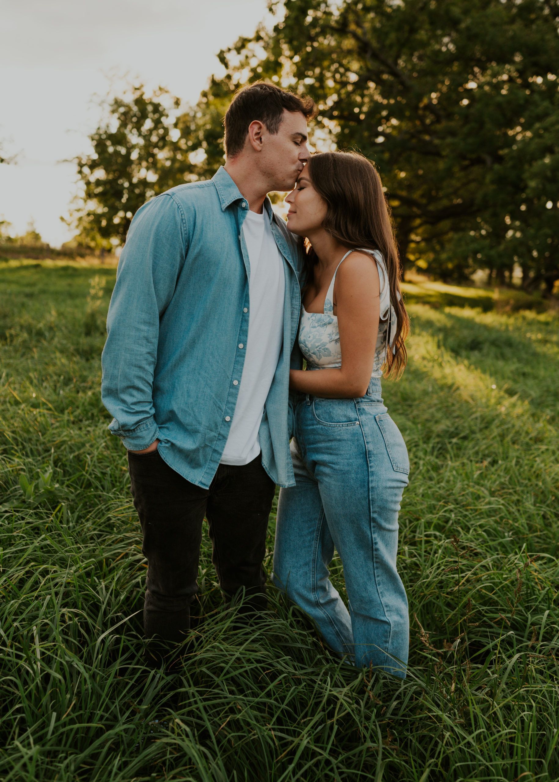 videographer filming a couple outdoors at golden hour