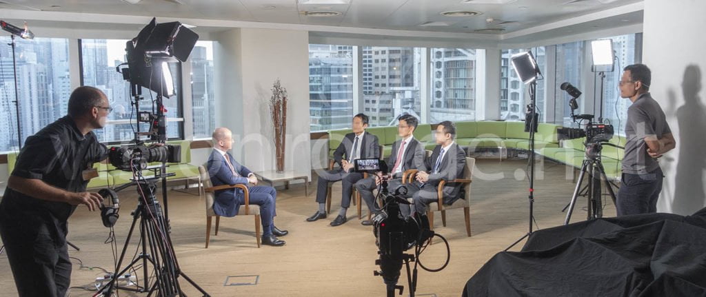 videographer filming a panel discussion at a corporate conference