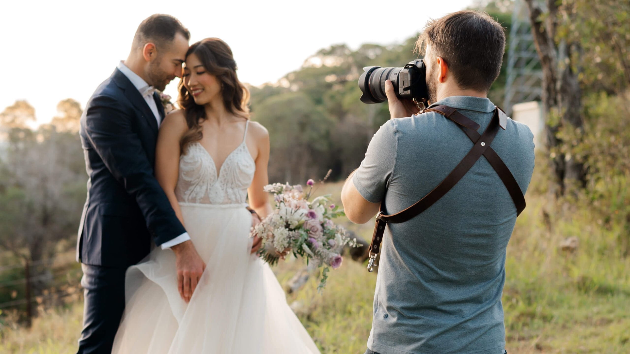 wedding videographer filming couple's first look outdoors