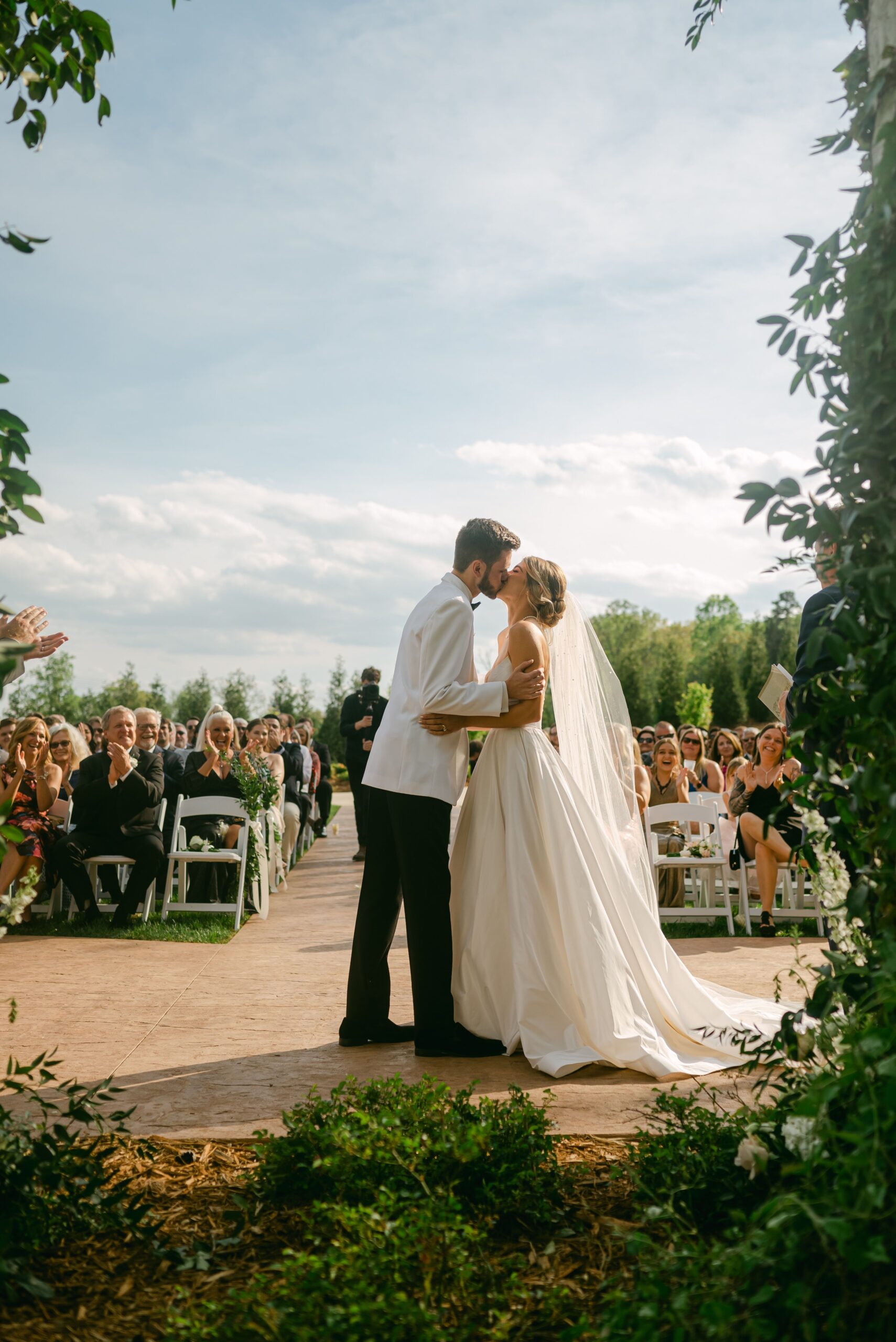 wedding videographer filming first kiss at ceremony