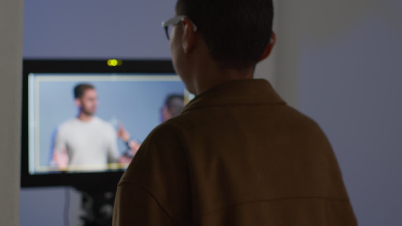 director watching monitor as actors perform