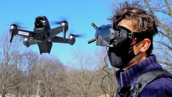 fpv drone pilot flying with goggles at outdoor shoot