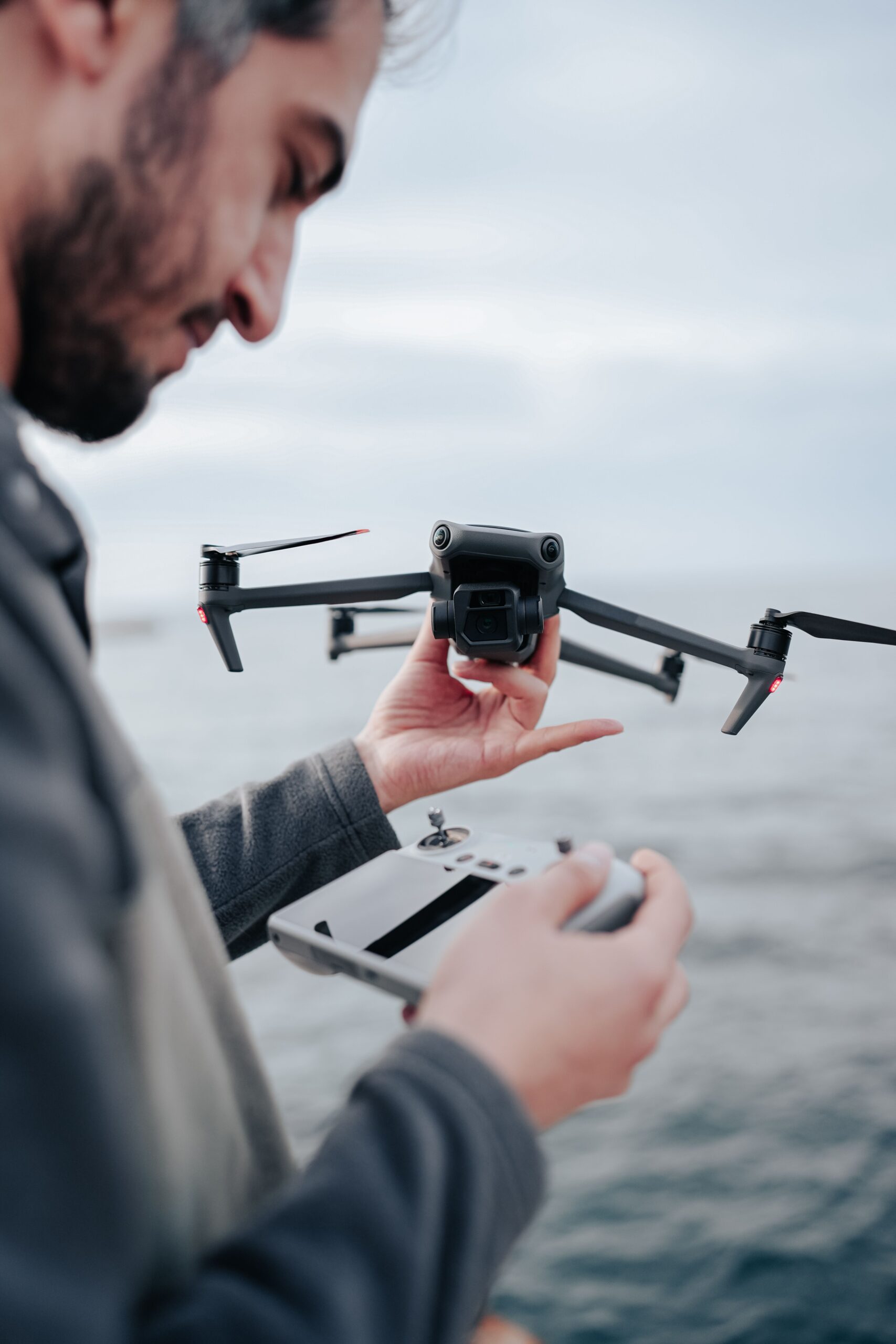 pilot holding drone controller beside listed house
