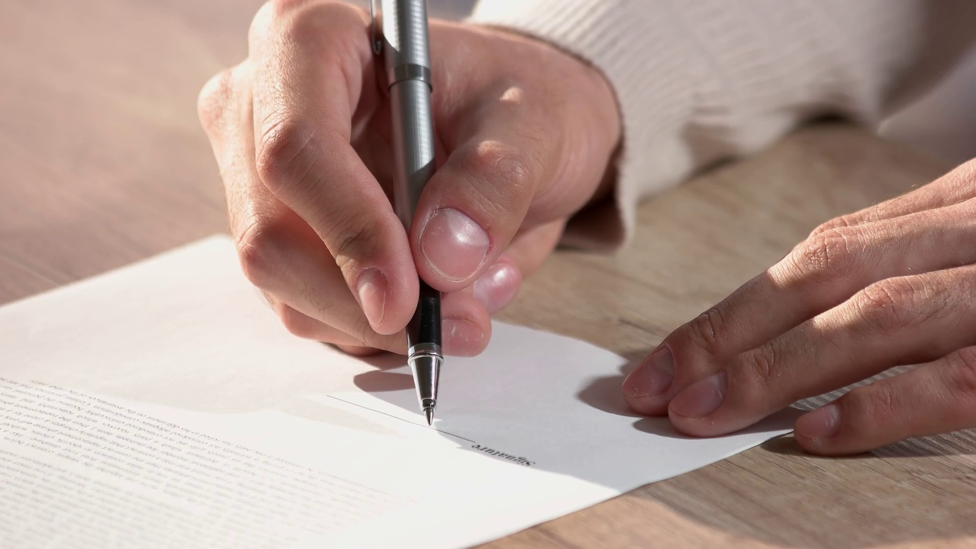 person signing videography contract with pen